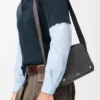 Bolso mensajero Pebble mediano en piel de becerro granulada flexible, gris oscuro