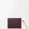Cartera compacta con nudo en piel de becerro napa brillante Burdeos oscuro/Citrino claro Cartera compacta con nudo en piel de becerro napa brillante Burdeos oscuro/Citrino claro