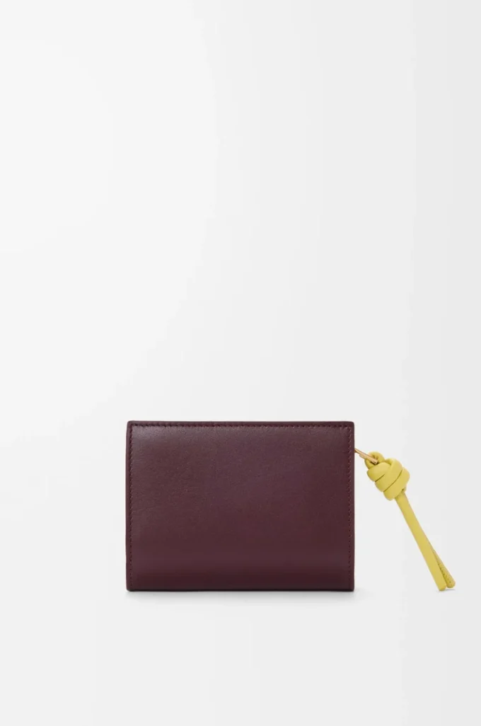 Cartera compacta con nudo en piel de becerro napa brillante Burdeos oscuro/Citrino claro Cartera compacta con nudo en piel de becerro napa brillante Burdeos oscuro/Citrino claro