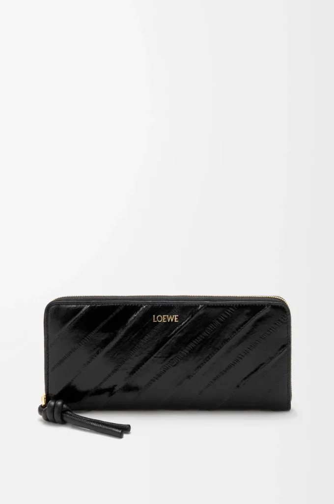 Cartera con cremallera alrededor y nudo en piel de anguila. Negro