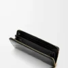 Cartera con cremallera alrededor y nudo en piel de anguila. Negro