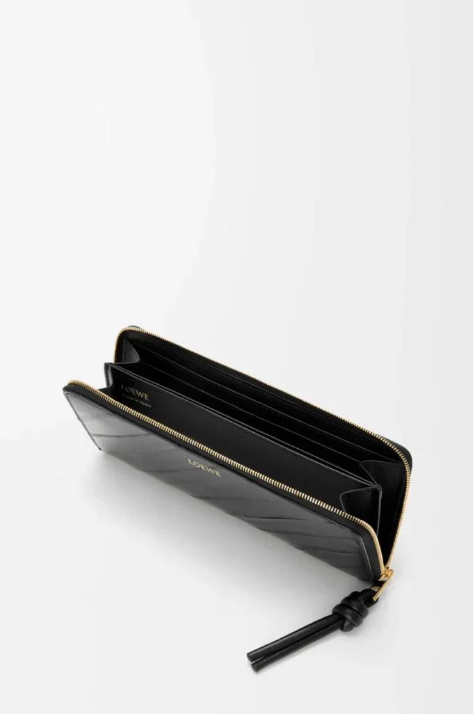 Cartera con cremallera alrededor y nudo en piel de anguila. Negro