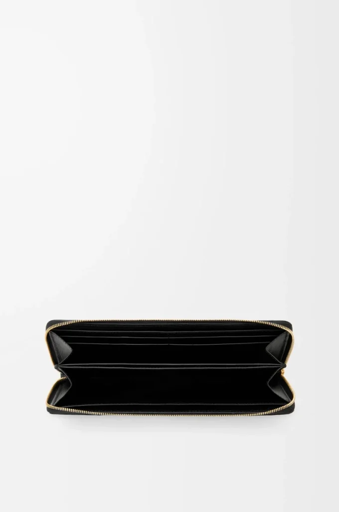 Cartera con cremallera alrededor y nudo en piel de anguila. Negro