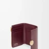 Cartera pequeña vertical Pebble en piel de becerro napa brillante color burdeos