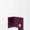 Cartera plegable de tres pliegues en piel de becerro granulado color ciruela Cartera plegable de tres pliegues en piel de becerro granulado color ciruela
