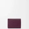 Cartera plegable de tres pliegues en piel de becerro granulado color ciruela Cartera plegable de tres pliegues en piel de becerro granulado color ciruela