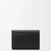 Cartera vertical pequeña en piel de becerro lisa y granulada. Cartera vertical pequeña en piel de becerro lisa y granulada.