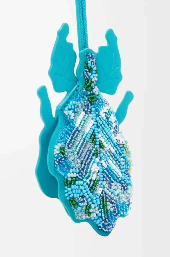 Colgante para llavero con forma de insecto hoja en piel con cuentas turquesa intenso